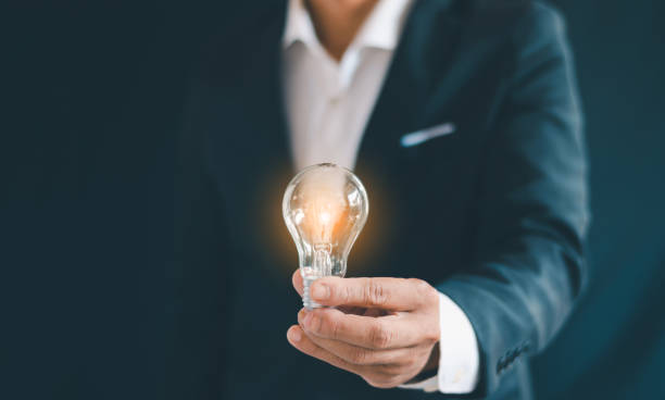 istock The businessman holds a light bulb in his hand, thinking 2168086179
