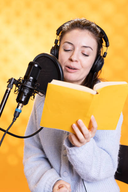 istock Cheerful lady narrating book to produce audiobook, studio background 2168086187