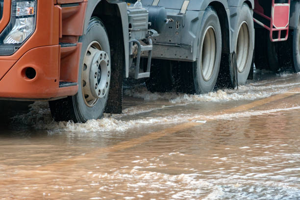 Muddy rain from a heavy rainy season flooded main roads connecting the district, making it difficult for cars to pass through and causing engine failures, in motion, car insurance concept.