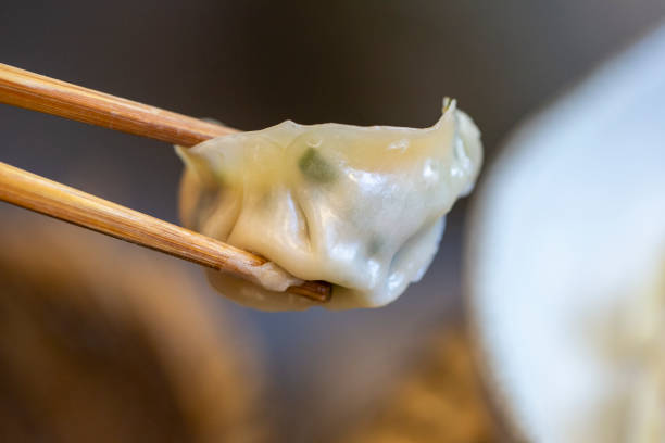 Close up of holding a Chinese dumpling with chopsticks