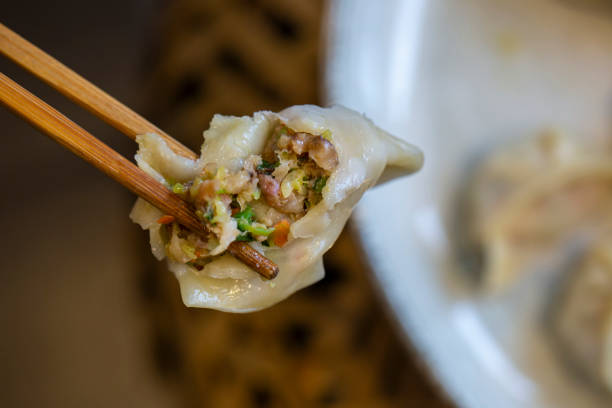 istock Close up of someone holding a dumpling with chopsticks 2168088299