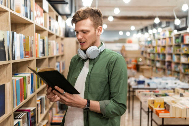 istock Student with Headphones and Open Book in Library 2168090162