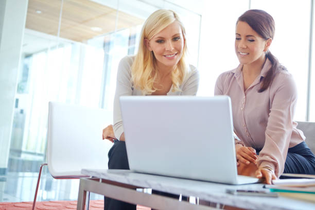 istock Women, laptop and teamwork with reading in office, thinking or happy for problem solving at company. Business people, partnership and smile for collaboration, stats and solution at insurance agency 2168090533