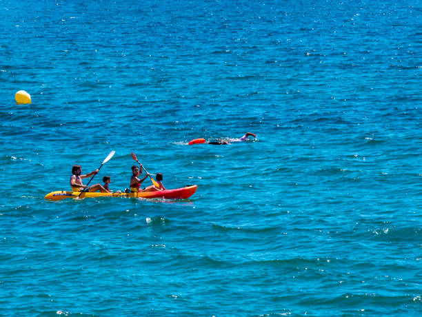 Spain, Almería, San Juan de los Terreros, August 17, 2024. A family in a canoe and another person swims in the Mediterranean Sea.