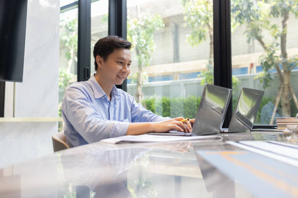 istock Smiling Man Working on Laptop at Desk 2168093923
