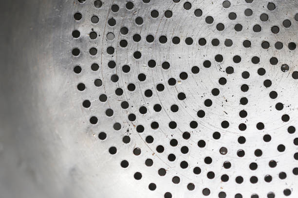 istock Metal kitchen strainer with a perforated surface. Small holes texture. 2168095170