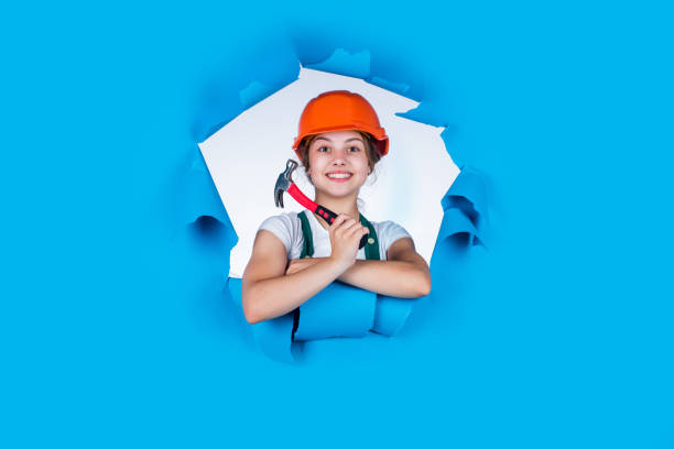 istock Kid builder girl. occupation learning concept. kid in workshop training to use hand instrument. girl wearing engineer clothes. Tools to improve yourself. Foreman inspector love working 2168095341