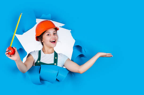 istock happy kid engineer with tape measure tool in hard hat, presenting productimprove 2168095344