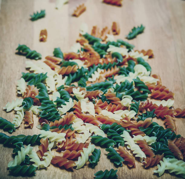 Background of uncooked Rotini pasta in three colors. Colorful pasta pattern