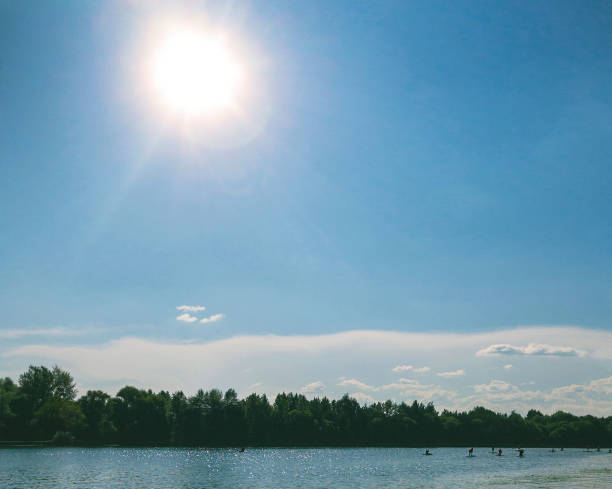 group of sup boarders drives along river