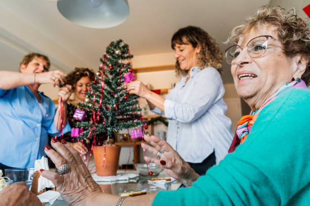 istock Senior friends arranging christmas tree decorations at home 2168100031