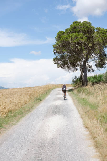 istock Young woman bicycles down rural road 2168102097