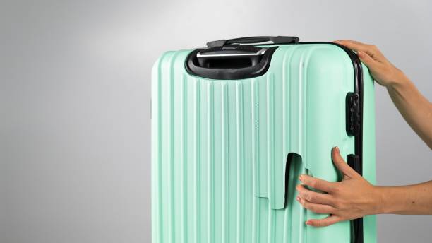 istock A woman demonstrates a broken suitcase on a white background. Damaged baggage during the flight. 2168102980