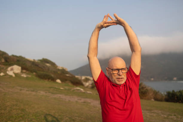 Elderly Caucasian man stretching in a park
