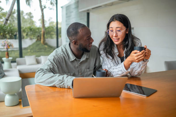 istock Asian Woman and Black Man Collaborating at Home Office 2168105229