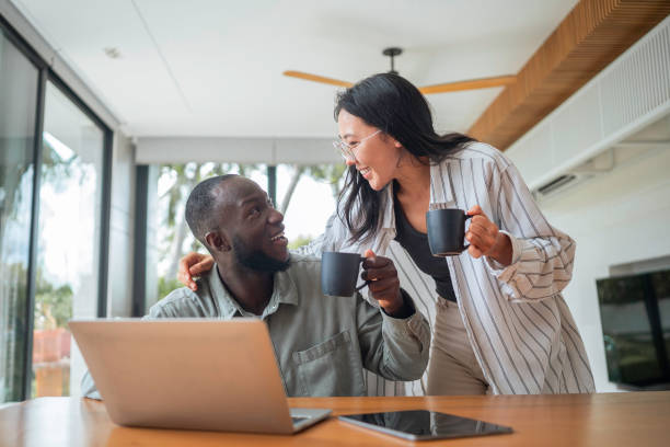 istock Asian Woman and Black Man Collaborating Remotely with Tech and Coffee 2168105232