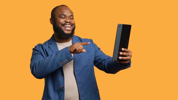 istock Man has funny conversation with friends in online videocall, studio background 2168106321