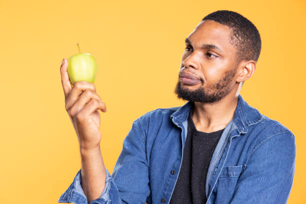 istock African american zero waste enthusiast looks at green apple on camera 2168106731