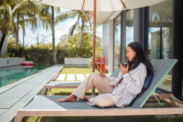 istock Asian Woman Enjoying Coffee and Tablet on Terrace 2168107048