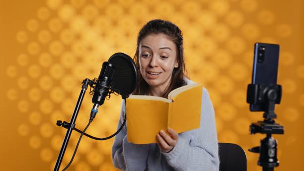 istock Voice actor films vlog at work, recording audiobook, studio background 2168108519