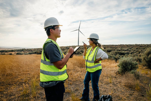 istock Technicians Working On Wind Farm With Turbines In Background 2168111112