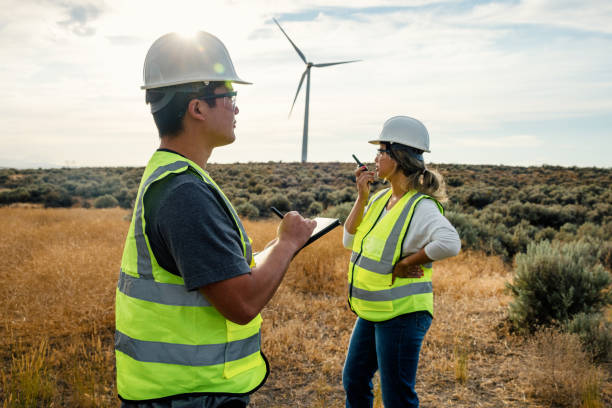 istock Technicians Working On Wind Farm With Turbines In Background 2168111141