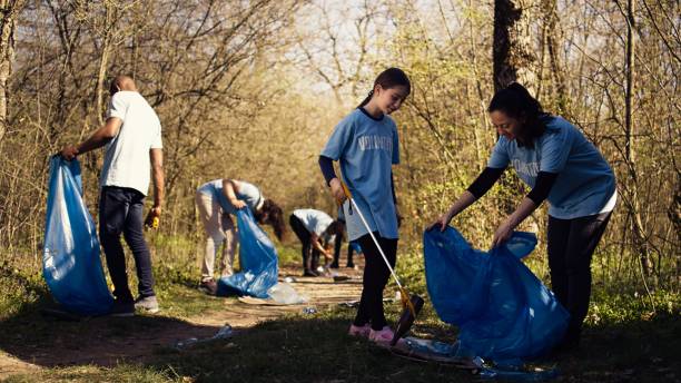 istock Mom and child collecting rubbish from the forest area using a long claw tool 2168111336