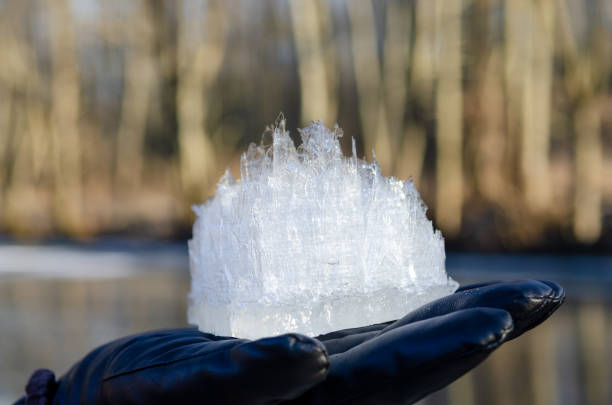 A close-up view of a large ice crystal held in a gloved hand