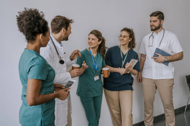 istock Doctors and nurses chatting during a coffee break in a hospital corridor 2168117194
