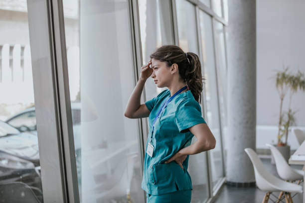istock Female doctor looking out window in hospital setting 2168117203