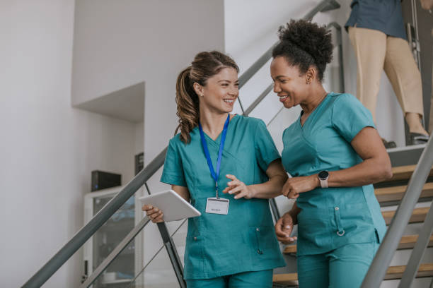 Two doctors discuss work while walking down stairs in hospital
