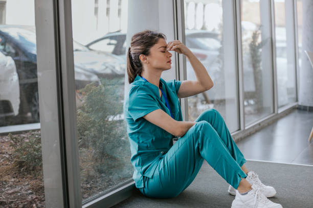 Doctor exhausted and sitting by hospital window