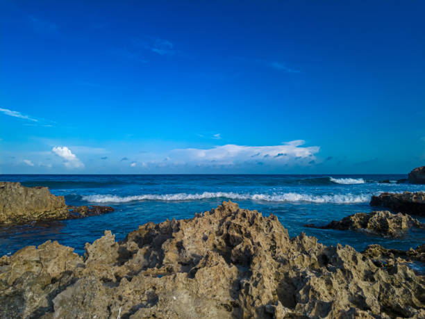 Stunning sunset over the rocky shores of Playa Gaviota, Cancun, with Caribbean waves gently crashing against the coast