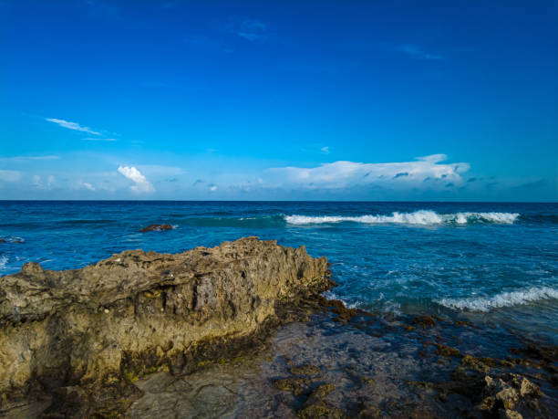 Stunning sunset over the rocky shores of Playa Gaviota, Cancun, with Caribbean waves gently crashing against the coast