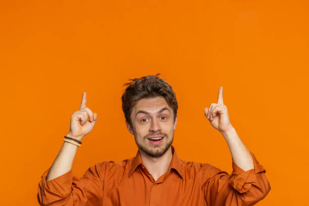istock Young man showing promotion, pointing overhead up on blank space place for your advertisement logo 2168120820