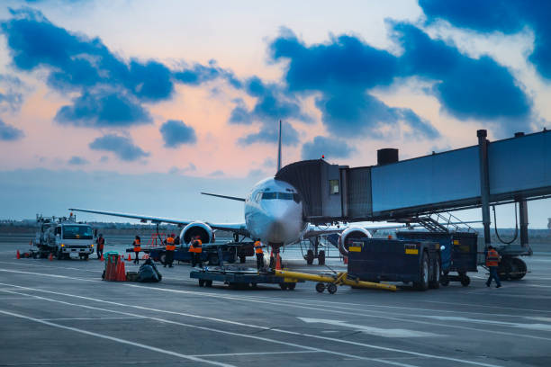 istock A large white airplane is parked on the tarmac with several people working on it 2168125487