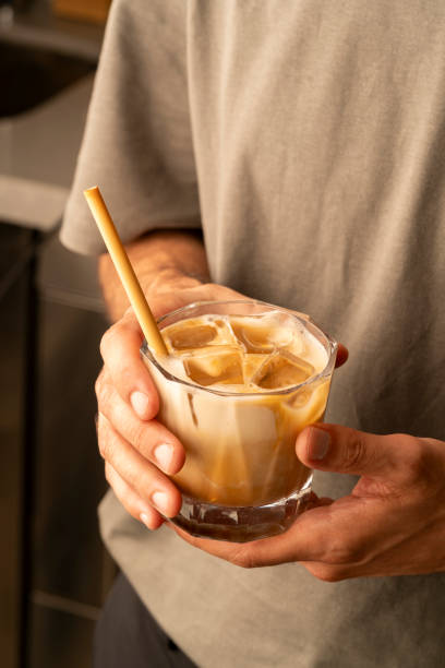 istock barista man serves iced latte coffee 2168125953