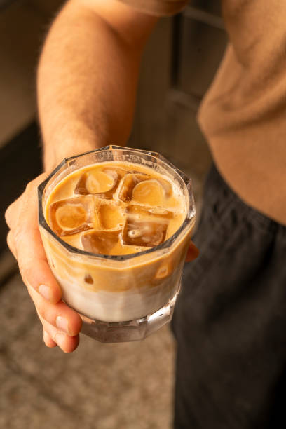 istock barista man serves iced latte coffee 2168125958