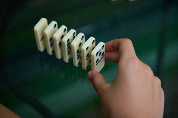 Close-up shot of dominoes standing on a tabletop in a residential home in Newcastle-upon-Tyne, North East England. One domino is in focus whilst the rest of the image is out of focus.