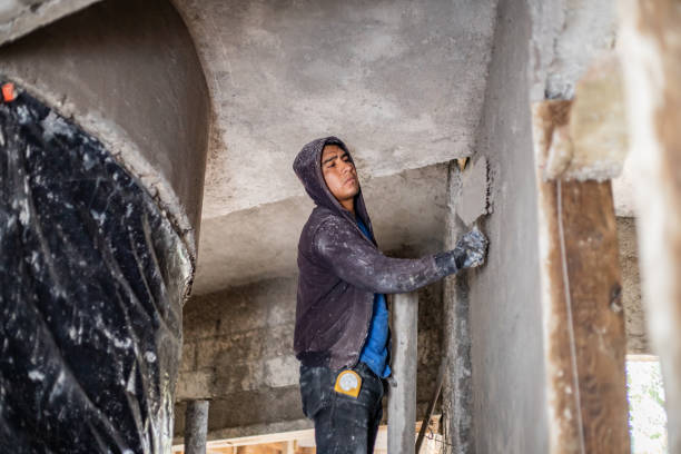 istock Male construction worker plastering walls with cement at construction site 2168131499