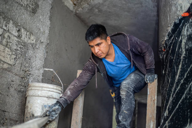 istock Male construction worker plastering walls with cement at construction site 2168131609
