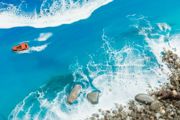 istock Resin art with blue ocean waves, boat and stone beach. Epoxy art composition 2168135833