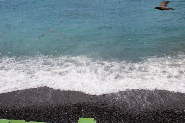Snapshot of the beach, sand and water with a hint of umbrellas showing through