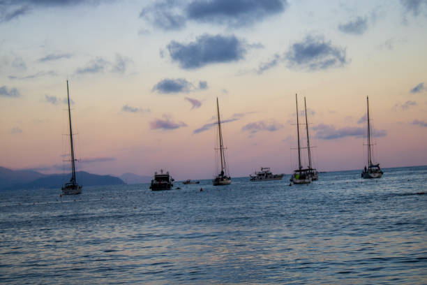 Sunset at the beach with boats on the scene