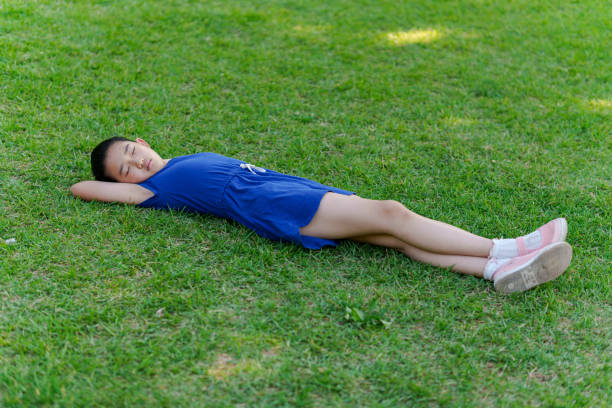 istock Little Girl Lying on Back the Grass 2168141897