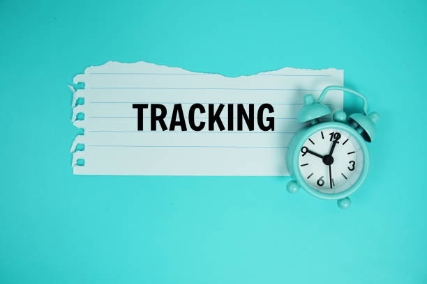 istock Tracking text written on paper torn with alarm clock top view on blue background 2168145077