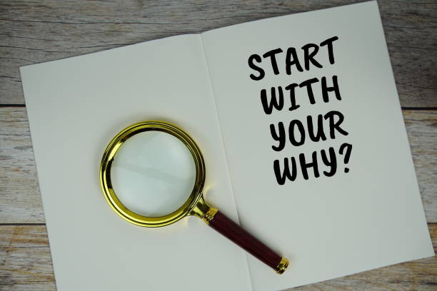 istock Start with your why? text on notebook page with magnifying glass top view on wooden background 2168145373