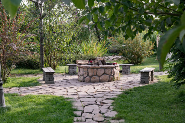istock Courtyard with fire pit and benches. Beautiful garden patio design with pergola and fire pit. A place to relax surrounded by lush nature. 2168145403