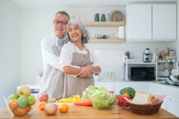 istock Affectionate elderly couple standing in a bright kitchen, embracing each other warmly and smiling at the camera. Togetherness, healthy lifestyle and retirement lifestyle concept. 2168149071