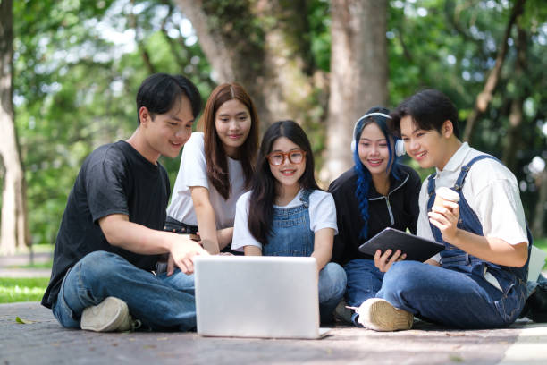istock Group of students sitting together outdoors and using laptop. Education concept. 2168149189
